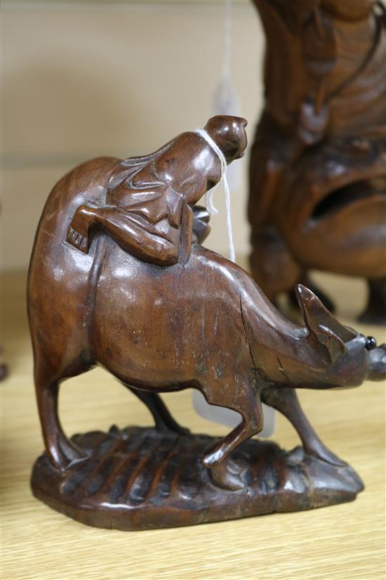 Three Chinese figural wood carvings and a soapstone carving of a child riding a water buffalo,